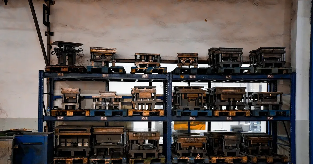 Mold bases and mold tooling stored on shelving in a mold shop, where hardened mold inserts are fitted